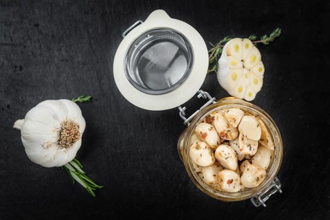 Marinated Garlic on a vintage slate slab (close-up shot, selective focus)
