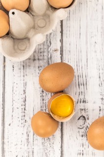 Some Raw Eggs on a vintage wooden table (selective focus, close-up shot)