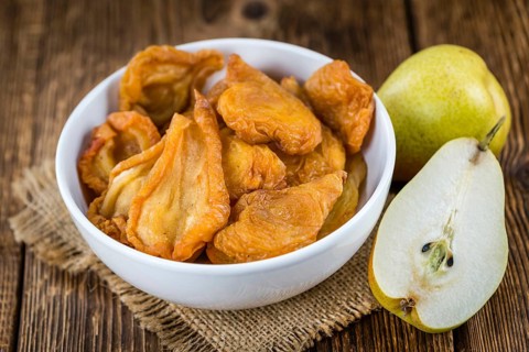 Wooden table with dried Pears (selective focus, close-up shot)