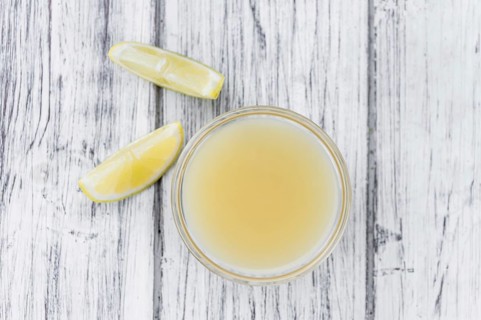 Homemade Lemon Juice on an wooden table (selective focus) as detailed close-up shot