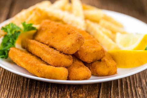 Portion of Fish Fingers (selective focus) on wooden background