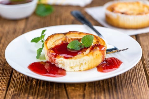 Cheesecake with Sauce on an old wooden table as detailed close-up shot (selective focus)