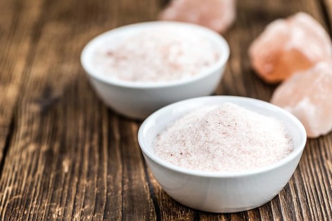 Pink Himalayan Salt on rustic wooden background (close-up shot)