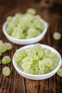 Portion of gummy candy (apple taste) on an old wooden table