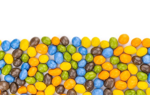 Chocolate coated peanuts isolated on white background (selective focus)
