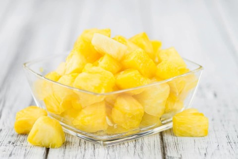 Sliced Pineapple on rustic wooden background as close-up shot