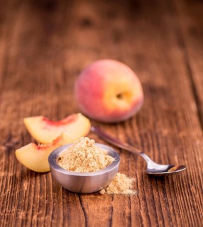 Ground Peaches as high detailed close-up shot on a vintage wooden table, selective focus