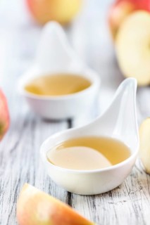 Portion of fresh made Applesauce (selective focus) on wooden background