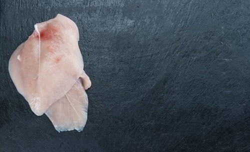 Raw Chicken Cutlet on a slate slab (detailed close-up shot)