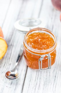 Wooden table with Peach Jam (selective focus, close-up shot)