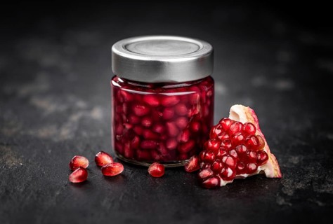 Healthy preserved Pomegranate seeds on a vintage slate slab (close-up shot, selective focus)
