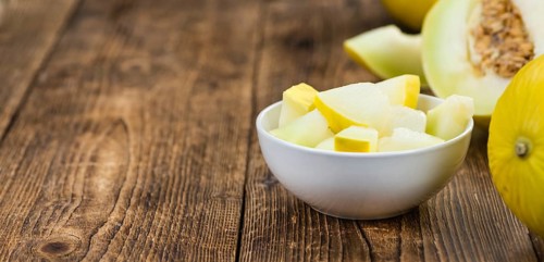 Honeydew Melon on an old wooden table as detailed close-up shot (selective focus)