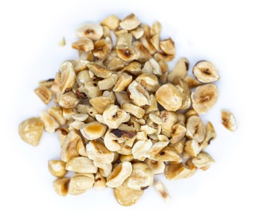 Freshly chopped Hazelnuts as detailed close up shot isolated on white background (selective focus)