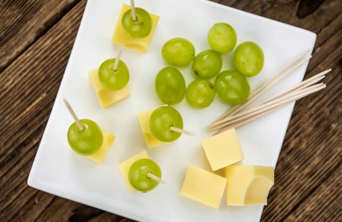 Cheese blocks with grapes as close-up shot (selective focus, partyfood)
