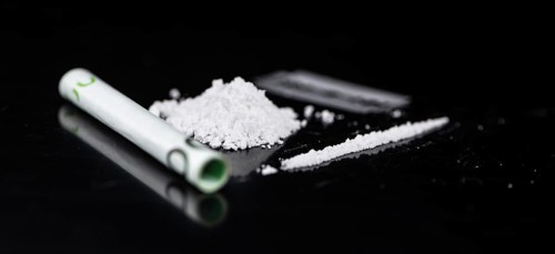 Cocaine on a dark plate as detailed close-up shot