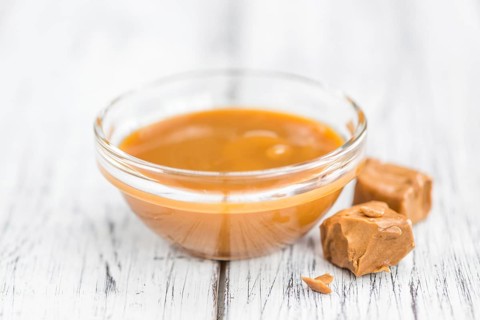 Caramel Sauce on a vintage background as detailed close-up shot (selective focus)