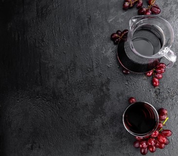 Portion of healthy Red Grape Juice on a slate slab (selective focus)