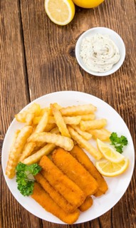 Fisch Sticks (close-up shot) on an old wooden table (selective focus)