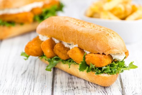 Fresh made Snack (Sandwich with Fish Sticks) on an old wooden table