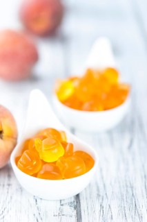 Gummy Peaches (detailed close-up shot) on an old wooden table