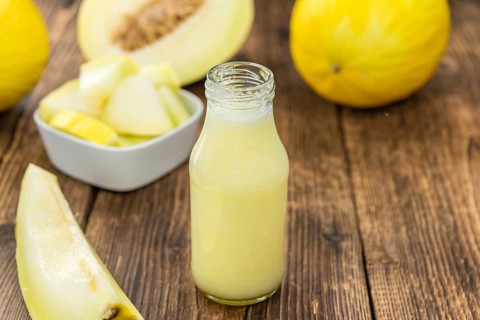 Fresh made Honeydew Melon smoothie (close-up shot, selective focus) on a wooden table