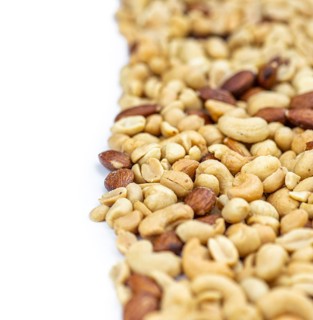Portion of roasted nuts isolated on white background as close up shot (selective focus)