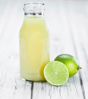 Fresh made Fresh Lime Juice on an old and rustic wooden table (selective focus, close-up shot)