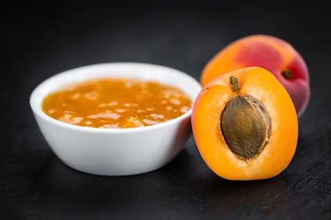 Portion of Apricot Jam on a rustic slate slab (selective focus, close-up shot)