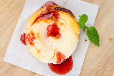 Fresh made Mini Cheesecake (with Sauce) on a vintage background (close-up shot)