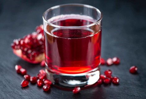 Some fresh Pomegranate juice on a vintage slate slab (selective focus, close-up shot)