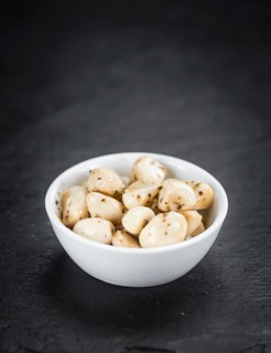 Portion of Garlic (preserved) on a rustic slate slab (selective focus, close-up shot)