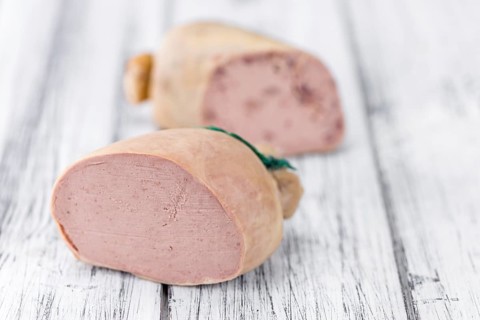 German Leberwurst on an old wooden table as detailed close-up shot (selective focus)