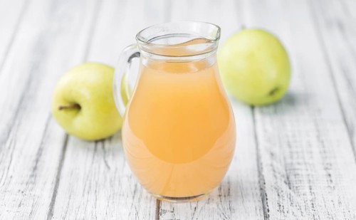 Apple Juice on an old wooden table as detailed close-up shot (selective focus)