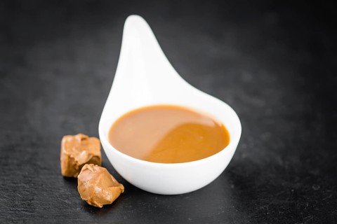 Caramel Sauce on a vintage slate slab (close-up shot, selective focus)