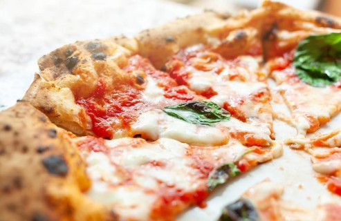 Close up of slices of pizza margherita with basil