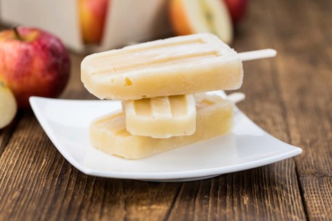 Vintage wooden table with Apple Popsicles (close-up shot, selective focus)