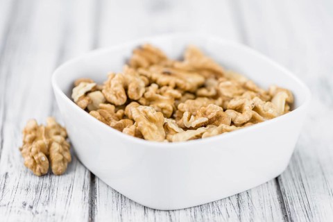 Walnuts (kernels) on an old wooden table as detailed close-up shot (selective focus)