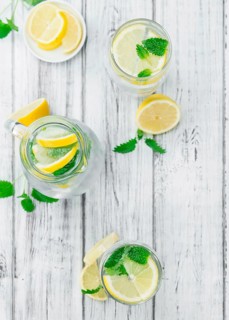 Homemade Lemonade on an wooden table (selective focus) as detailed close-up shot