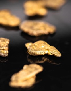 Gold Nuggets on dark background as detailed close up shot, selective focus