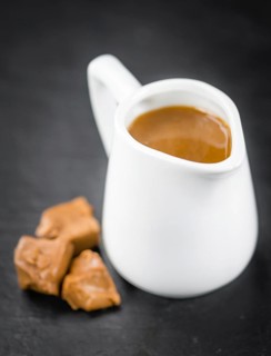 Portion of fresh Caramel Sauce (close-up shot, selective focus)