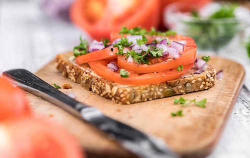 Portion of healthy Tomato Sandwich on an old wooden table (selective focus, close-up shot)