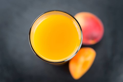 Some fresh Apricot Juice on a vintage slate slab (selective focus, close-up shot)