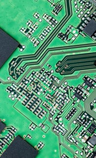 Green printed circuit board (PCB) close-up shot with a lot of electronic components