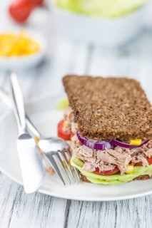 Old wooden table with Tuna sandwich (on wholemeal bread, selective focus)