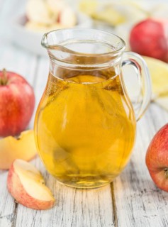 Apple Cider on an old wooden table as detailed close-up shot (selective focus)