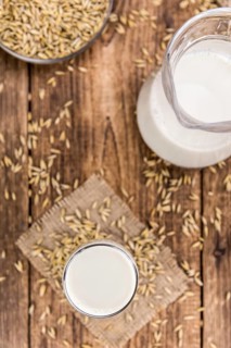 Healthy Oat Milk on a wooden table as detailed close-up shot (selective focus)