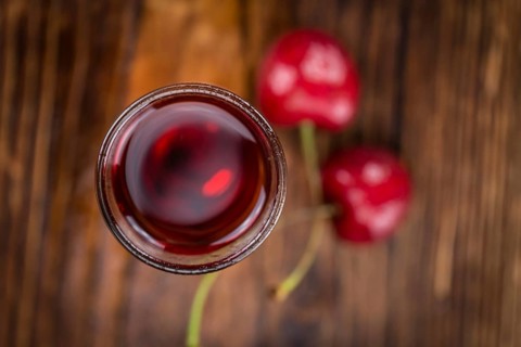 Homemade Cherry Liqueur on vintage background selective focus, close-up shot