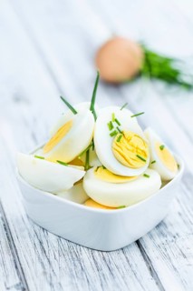 Halved Eggs on wooden background (close-up shot, selective focus)