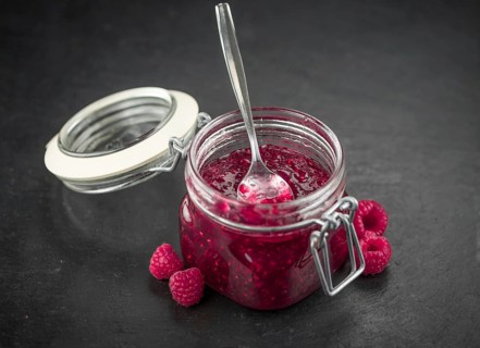 Some Raspberry Jam on a slate slab as detailed close-up shot, selective focus
