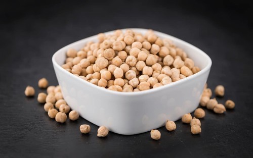 Some dried Chickpeas on a slate slab as detailed close-up shot, selective focus
